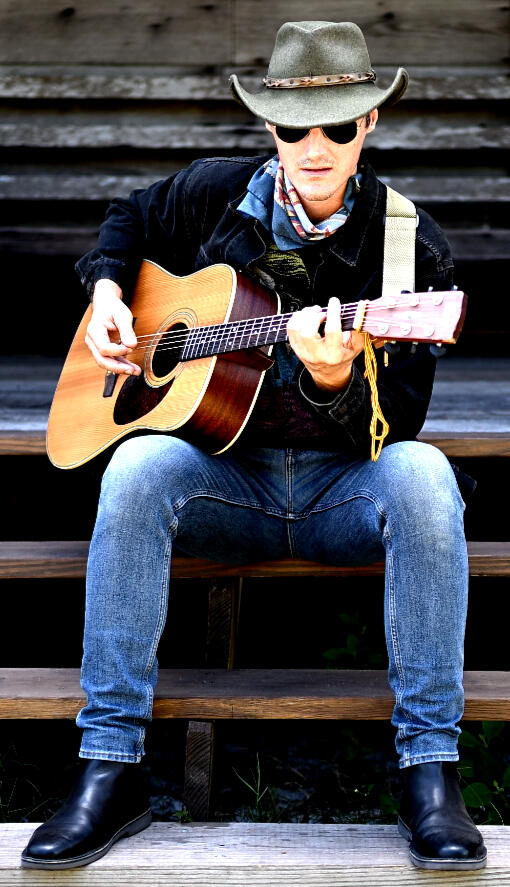 Justin Kaiser live music promotional poster A man in leather with a guitar advertises his services. Photo by Jacqueline Leonhardt.